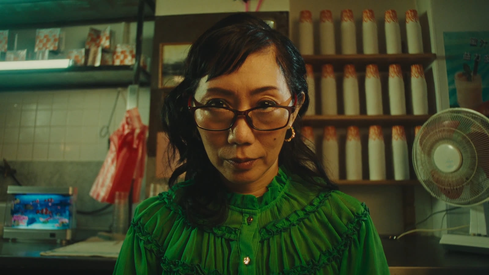 Woman in green looks into the lens