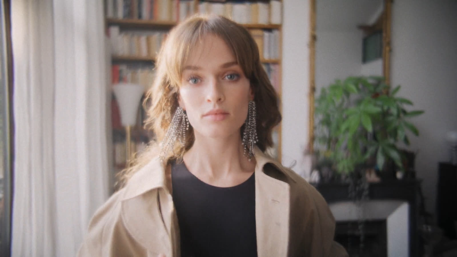 Woman in a trench coat looks into the lens